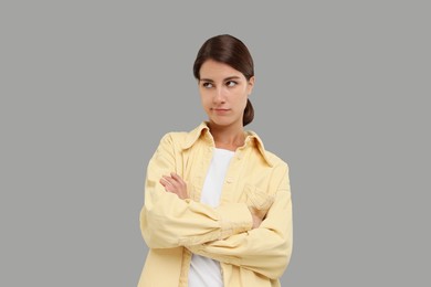 Photo of Resentful woman with crossed arms on grey background