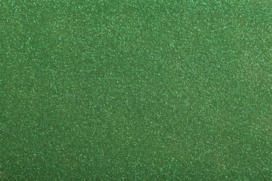 Photo of Beautiful shiny green glitter as background, closeup