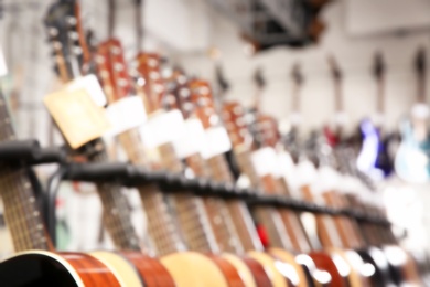 Row of different guitars in music store, blurred view