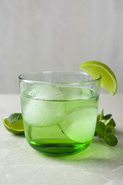 Photo of Delicious cocktail with lime and ice balls on grey table