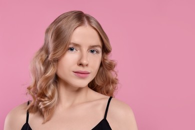 Portrait of beautiful woman with blonde hair on pink background. Space for text