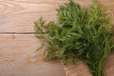 Sprigs of fresh dill on wooden table, top view. Space for text