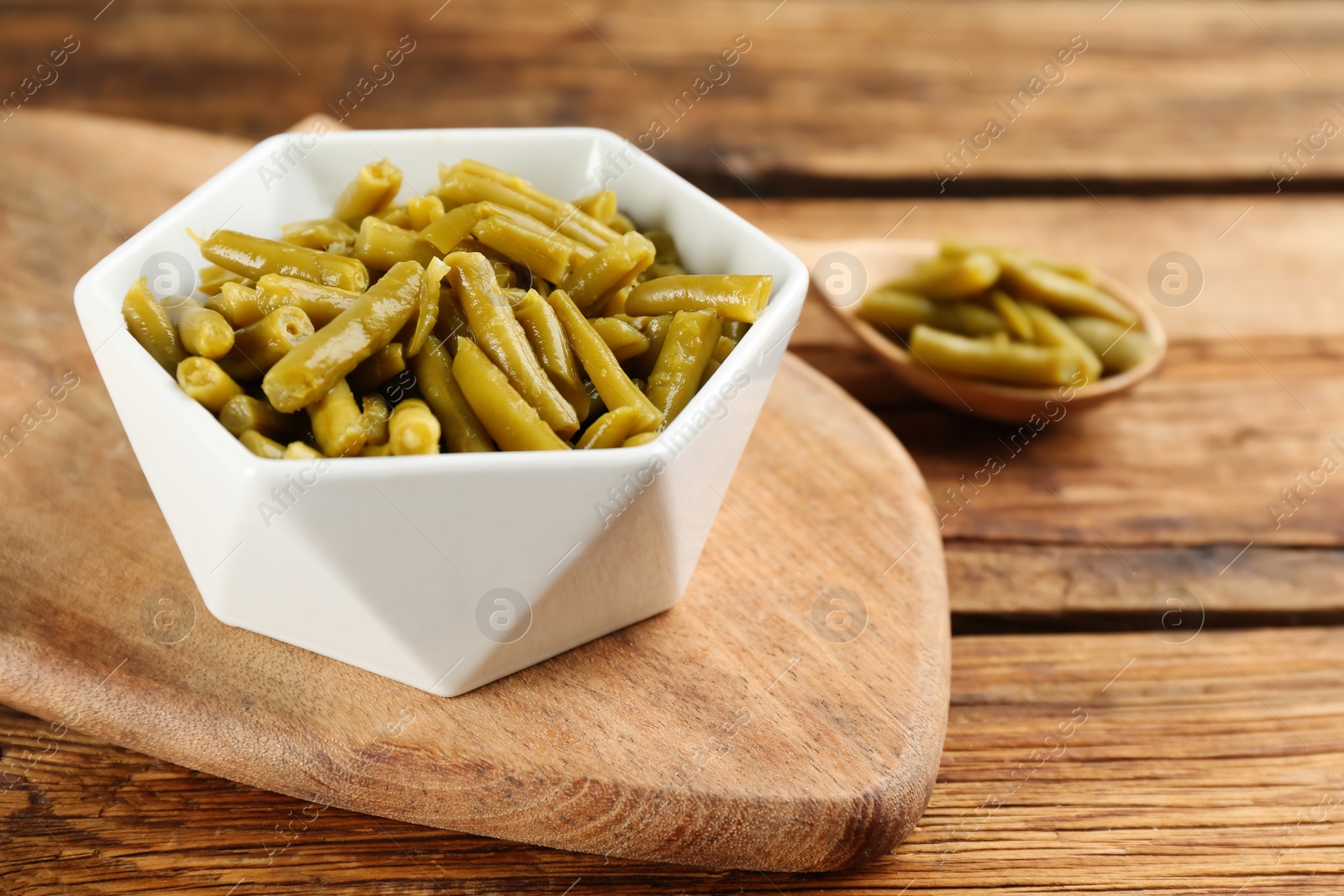 Photo of Canned green beans on wooden table, closeup