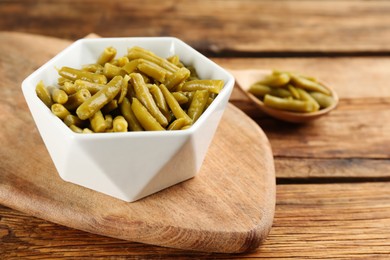 Canned green beans on wooden table, closeup