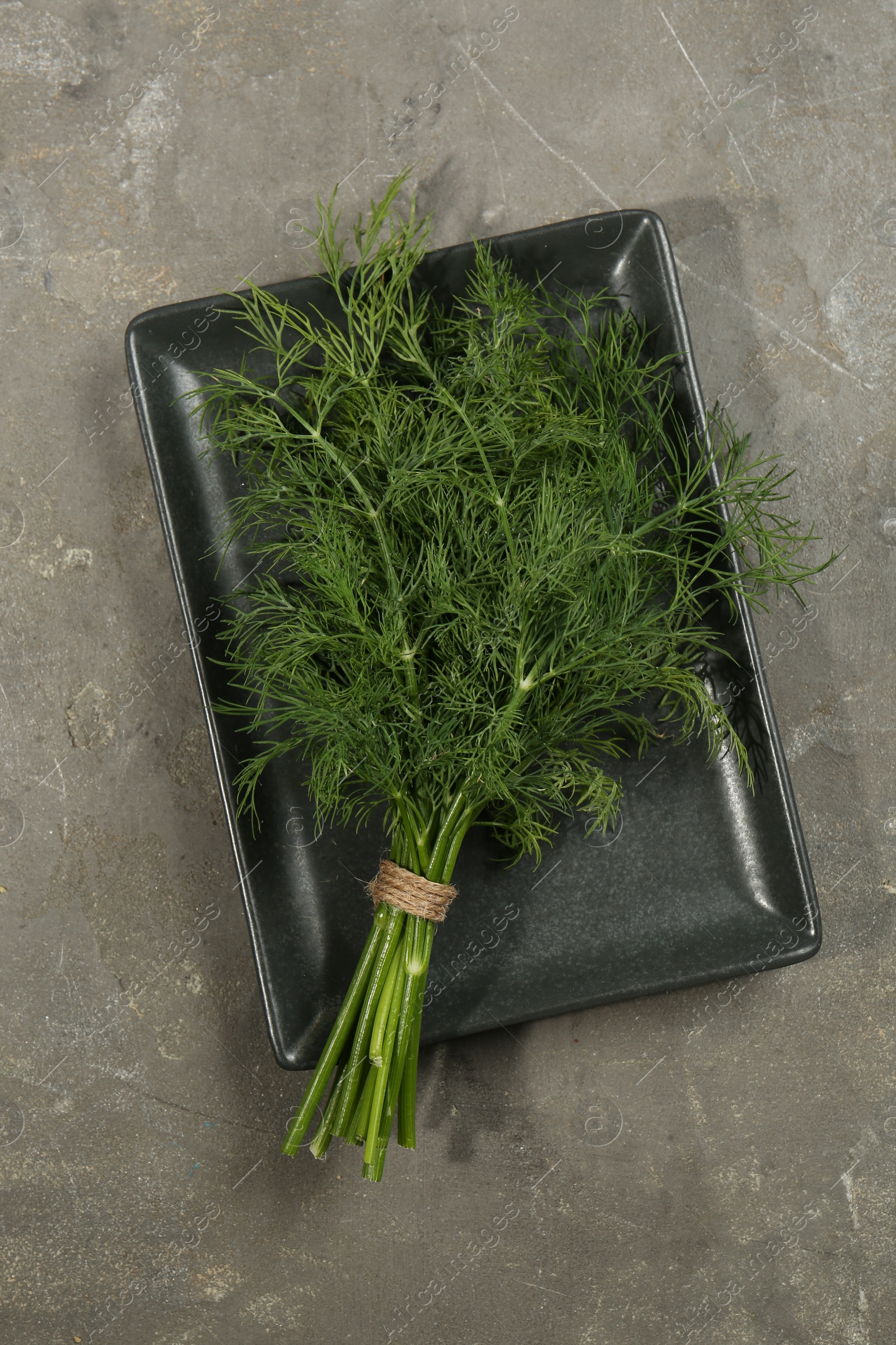 Photo of Bunch of fresh dill on grey table, top view