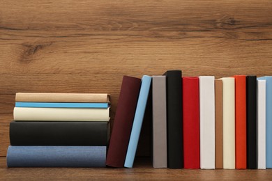 Many different hardcover books on wooden table