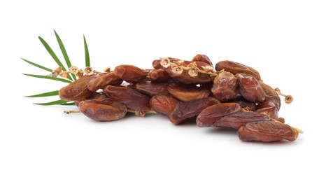 Photo of Sweet dates on branches and green leaves against white background. Dried fruit as healthy snack