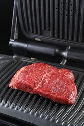 Photo of Cooking fresh beef cut on electric grill