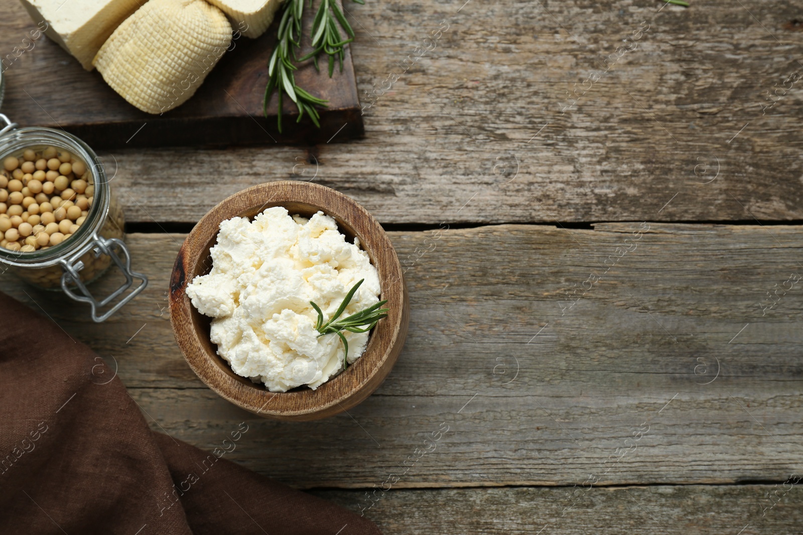 Photo of Delicious tofu cream cheese with rosemary on wooden table, flat lay. Space for text