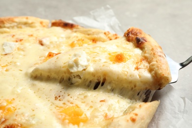 Photo of Taking slice of hot cheese pizza Margherita on table, closeup