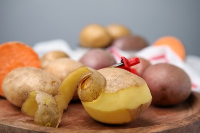 Photo of Different types of fresh potatoes wooden board, closeup