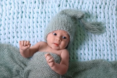 Photo of Cute newborn baby on light blue blanket, top view