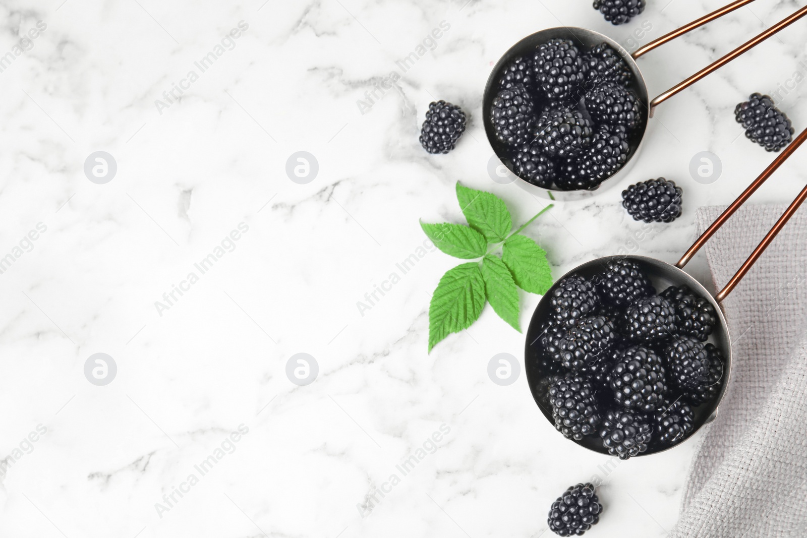 Photo of Flat lay composition with tasty ripe blackberries and space for text on marble table