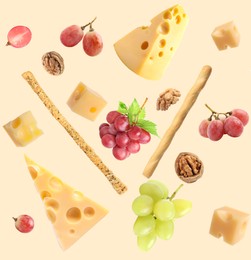 Image of Cheese, breadsticks, grapes and walnuts falling against beige background