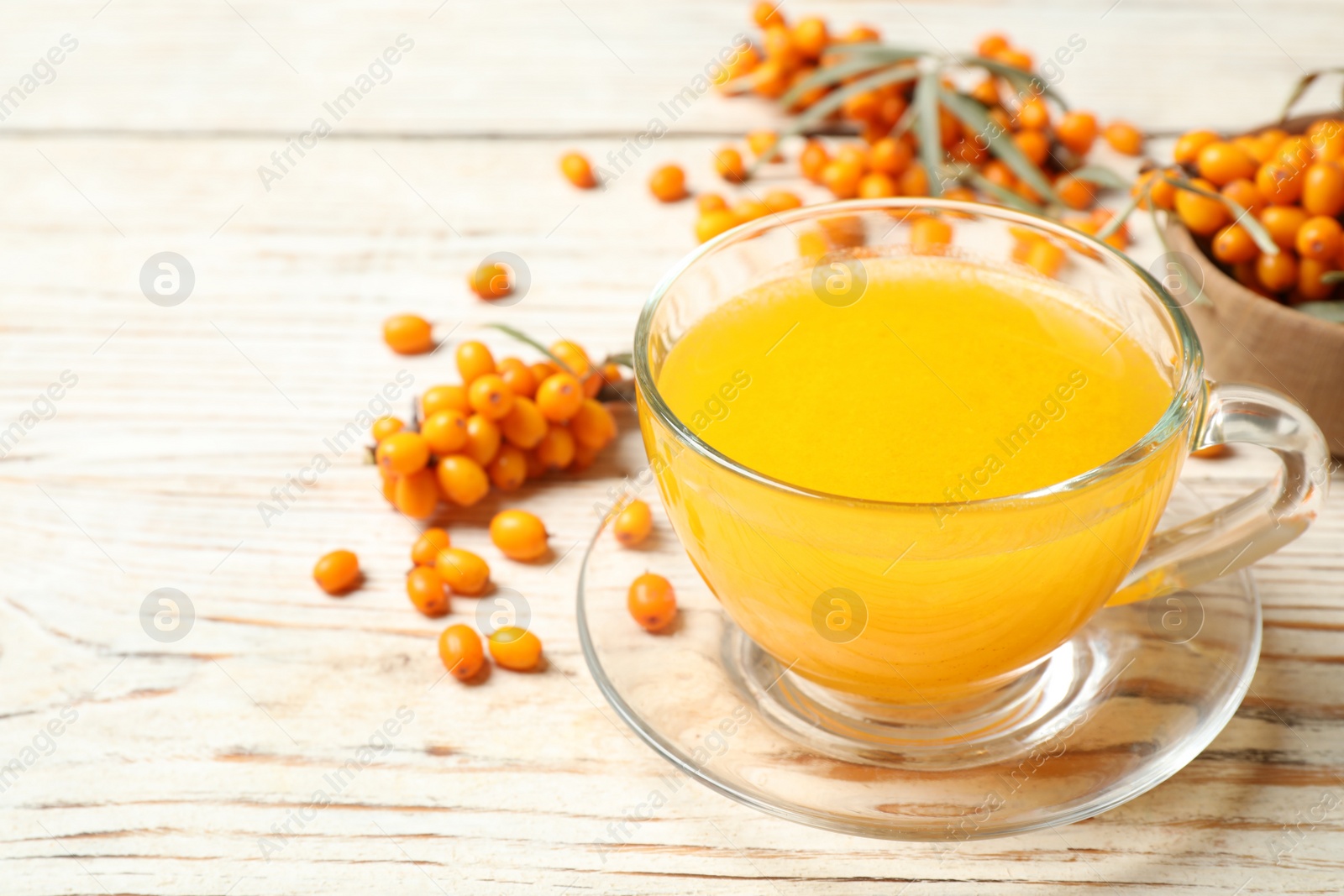 Photo of Fresh sea buckthorn tea on white wooden table