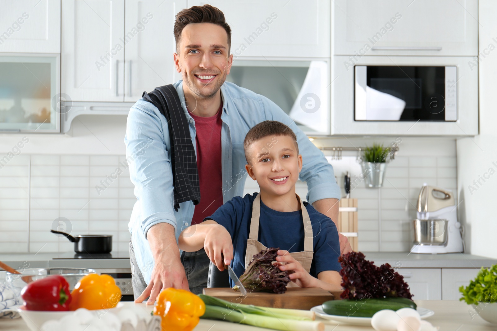 Photo of Dad and son cooking together in kitchen