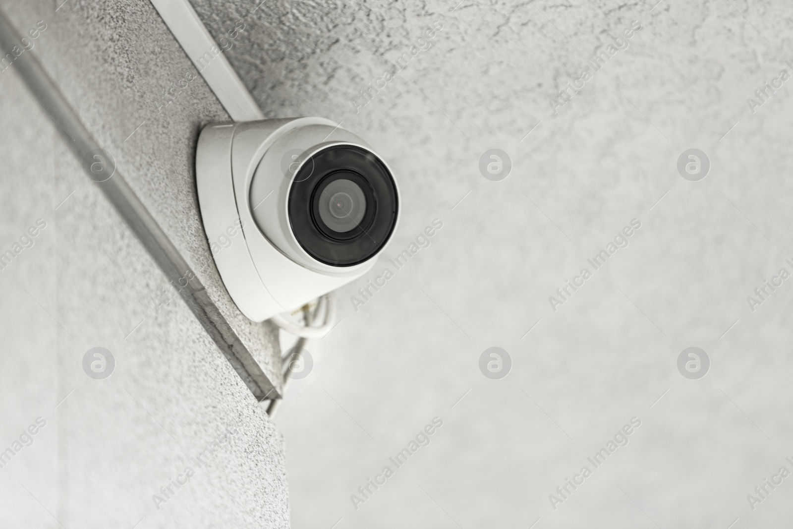 Photo of Modern CCTV security camera on building outdoors. Space for text