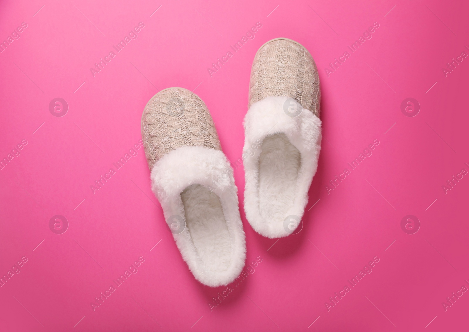 Photo of Pair of beautiful soft slippers on pink background, top view