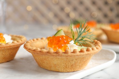 Delicious canapes with red caviar on table, closeup