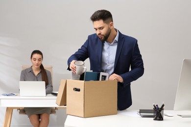 Dismissed man packing personal stuff into box in office