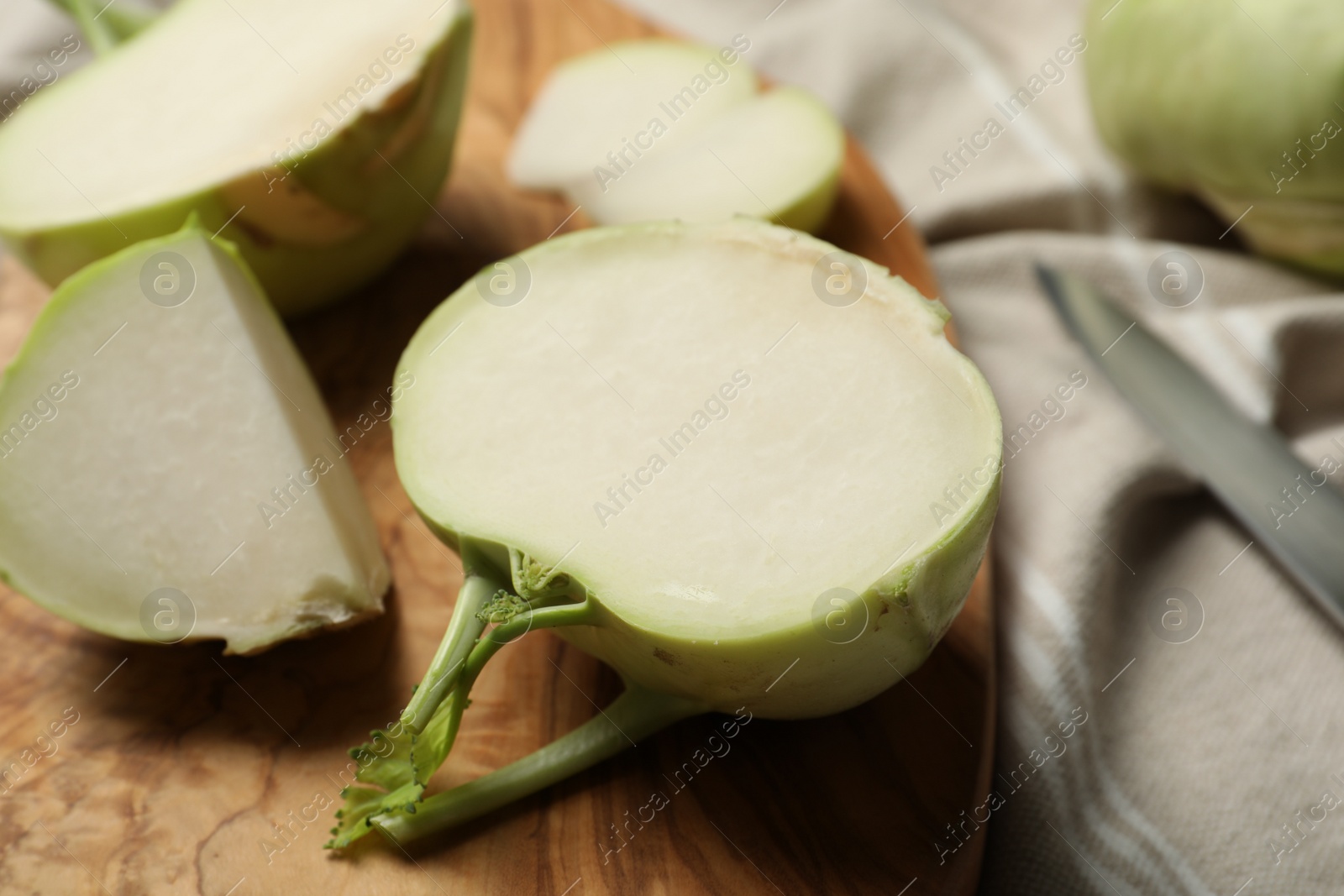 Photo of Cut kohlrabi plants on wooden board, closeup