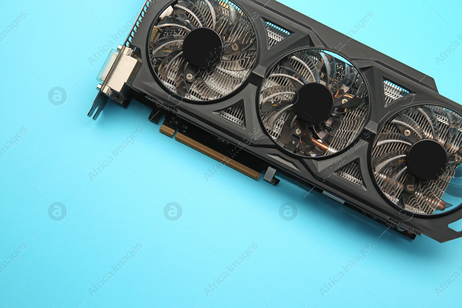 Photo of One graphics card on light blue background, top view. Space for text