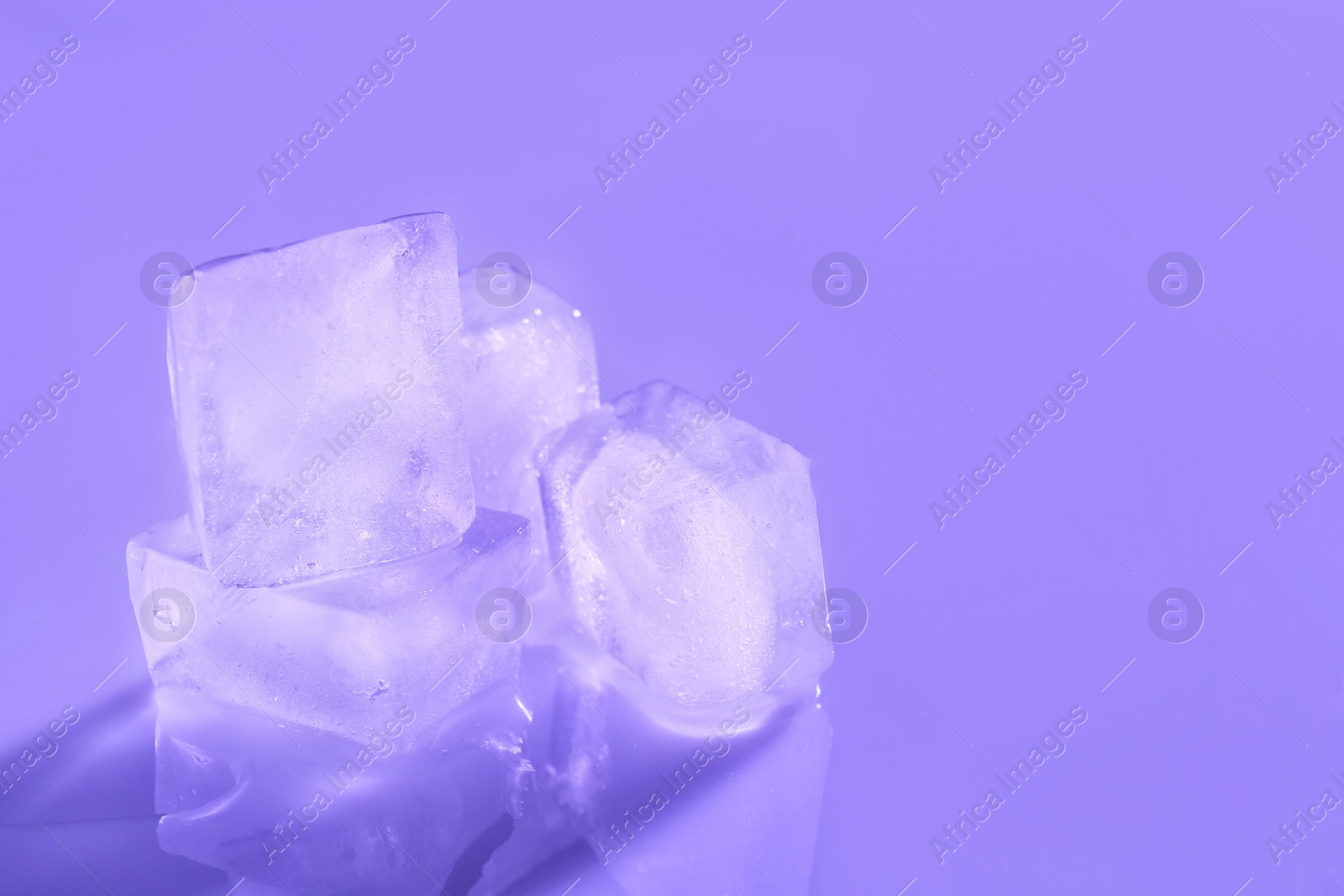 Photo of Ice cubes on color background. Space for text