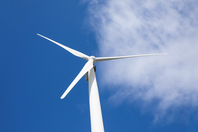 Wind turbine against beautiful blue sky, low angle view. Alternative energy source