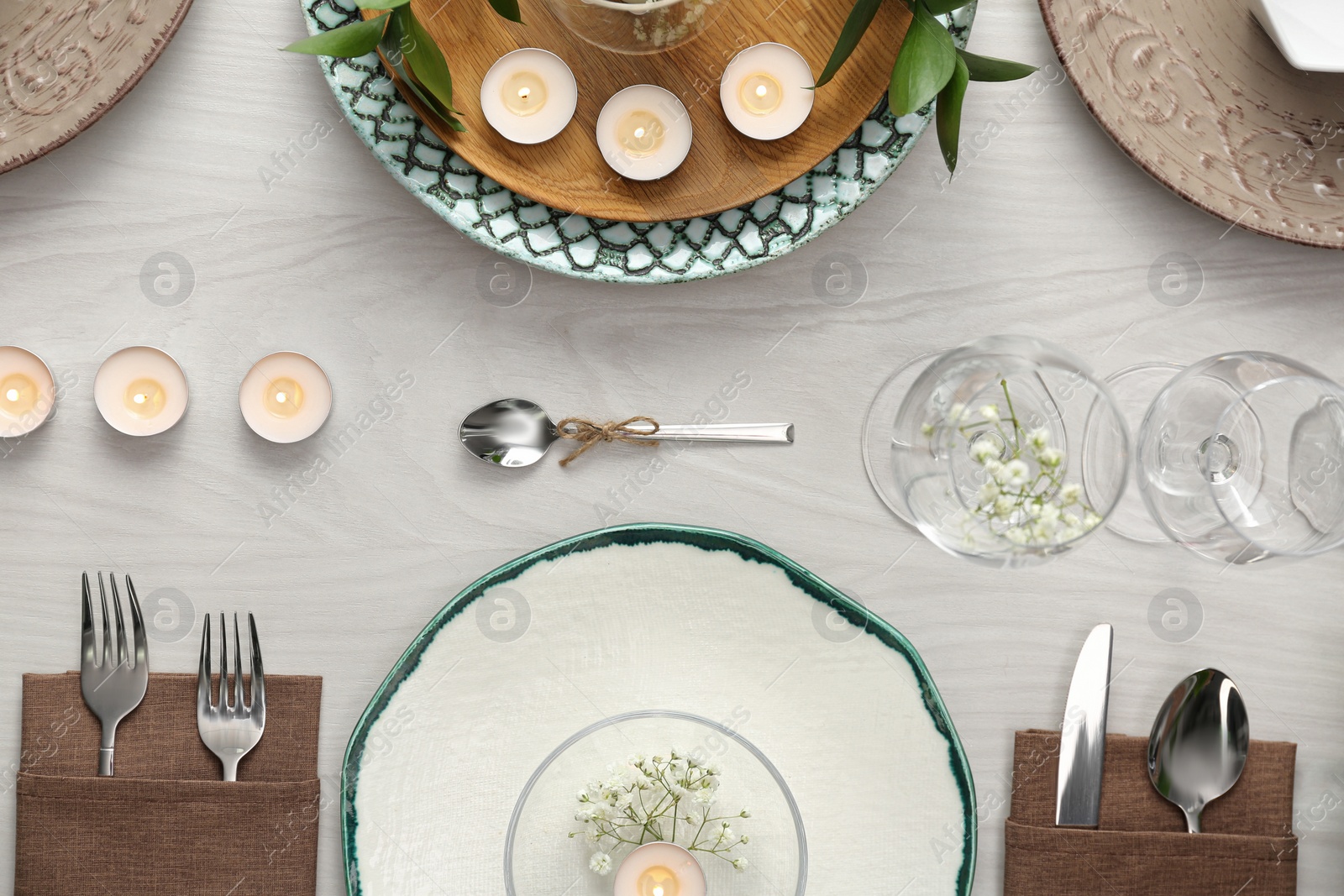 Photo of Elegant table setting with green plants on white wooden background, flat lay