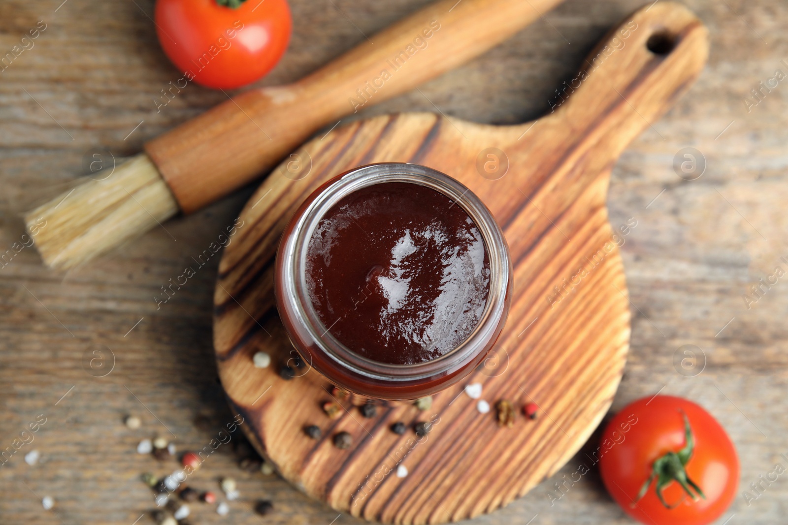 Photo of Flat lay composition with barbecue sauce on wooden background