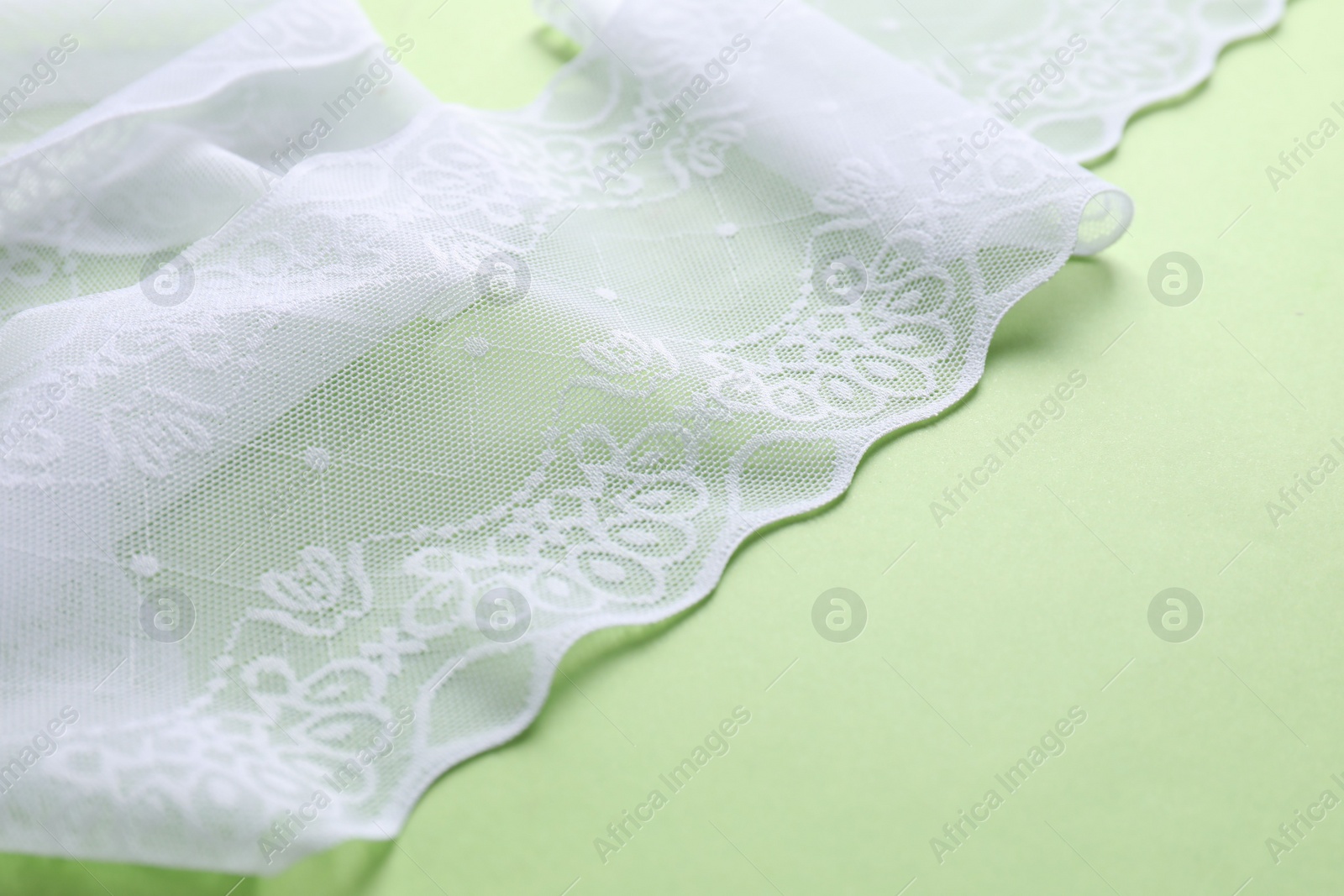 Photo of White lace on green background, space for text