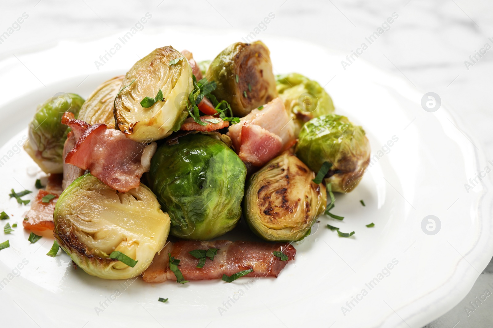 Photo of Delicious Brussels sprouts with bacon on plate, closeup