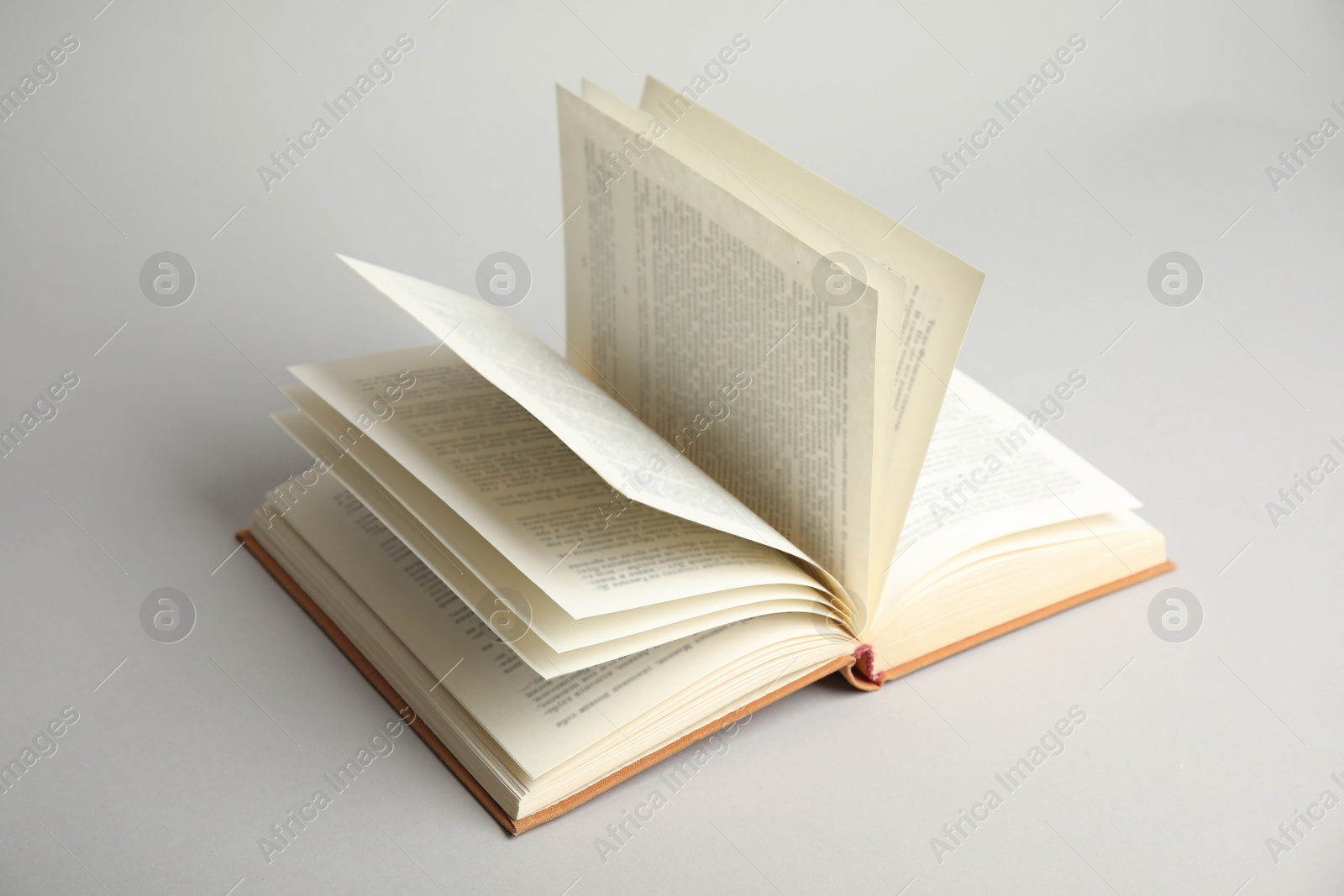 Photo of Open old hardcover book on light grey background