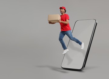 Courier with parcel flying out from huge smartphone on grey background. Delivery service. Space for text