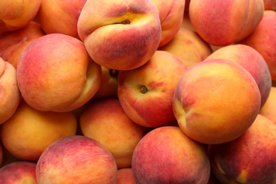 Photo of Fresh ripe peaches as background, top view