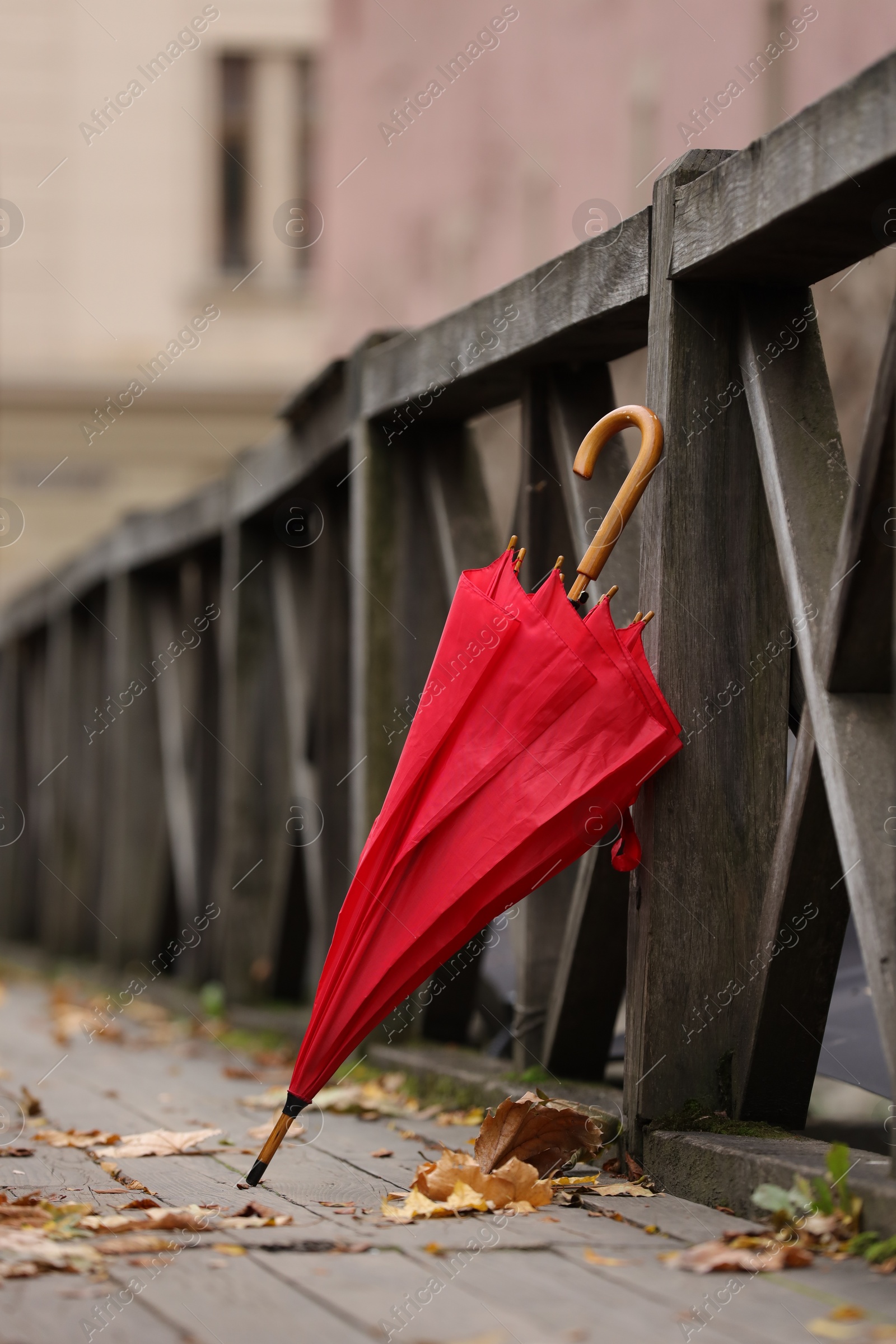 Photo of Autumn atmosphere. One red umbrella on city street