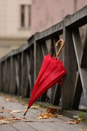 Photo of Autumn atmosphere. One red umbrella on city street