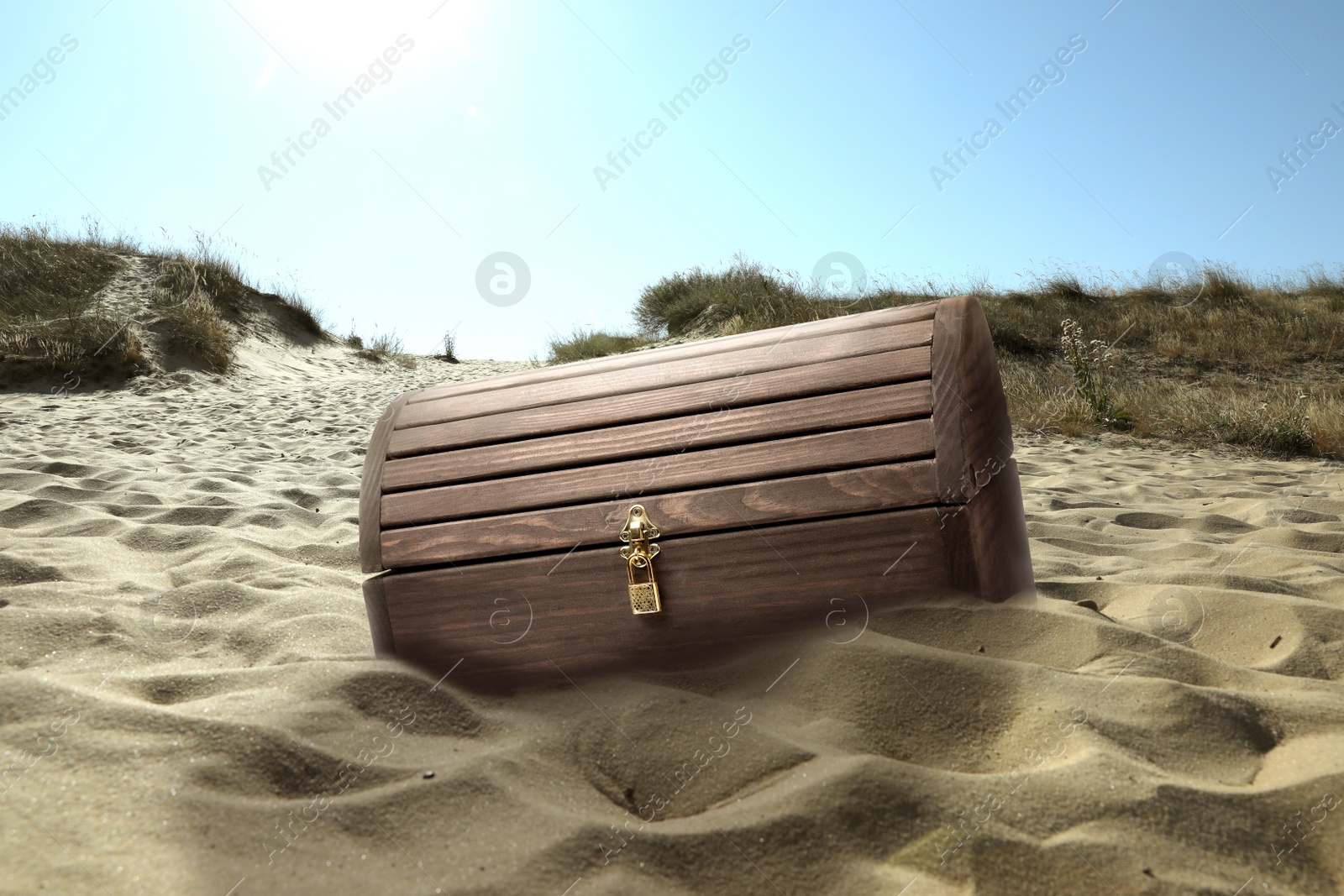 Image of Closed wooden treasure chest on sandy beach