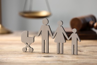 Family law. Figure of parents with children on wooden table, closeup