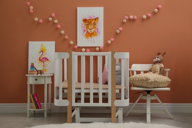 Photo of Cute pictures and crib in baby room interior