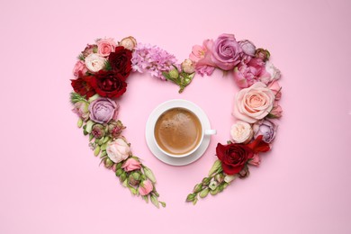 Beautiful heart shaped floral composition with cup of coffee on pink background, flat lay