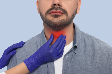 Endocrinologist examining thyroid gland of patient on grey background, closeup