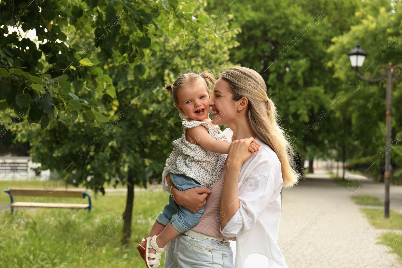 Photo of Happy mother with her daughter spending time together in park. Space for text