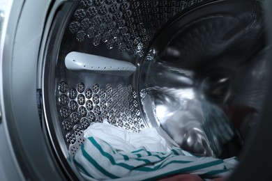 Modern washing machine drum with laundry, closeup