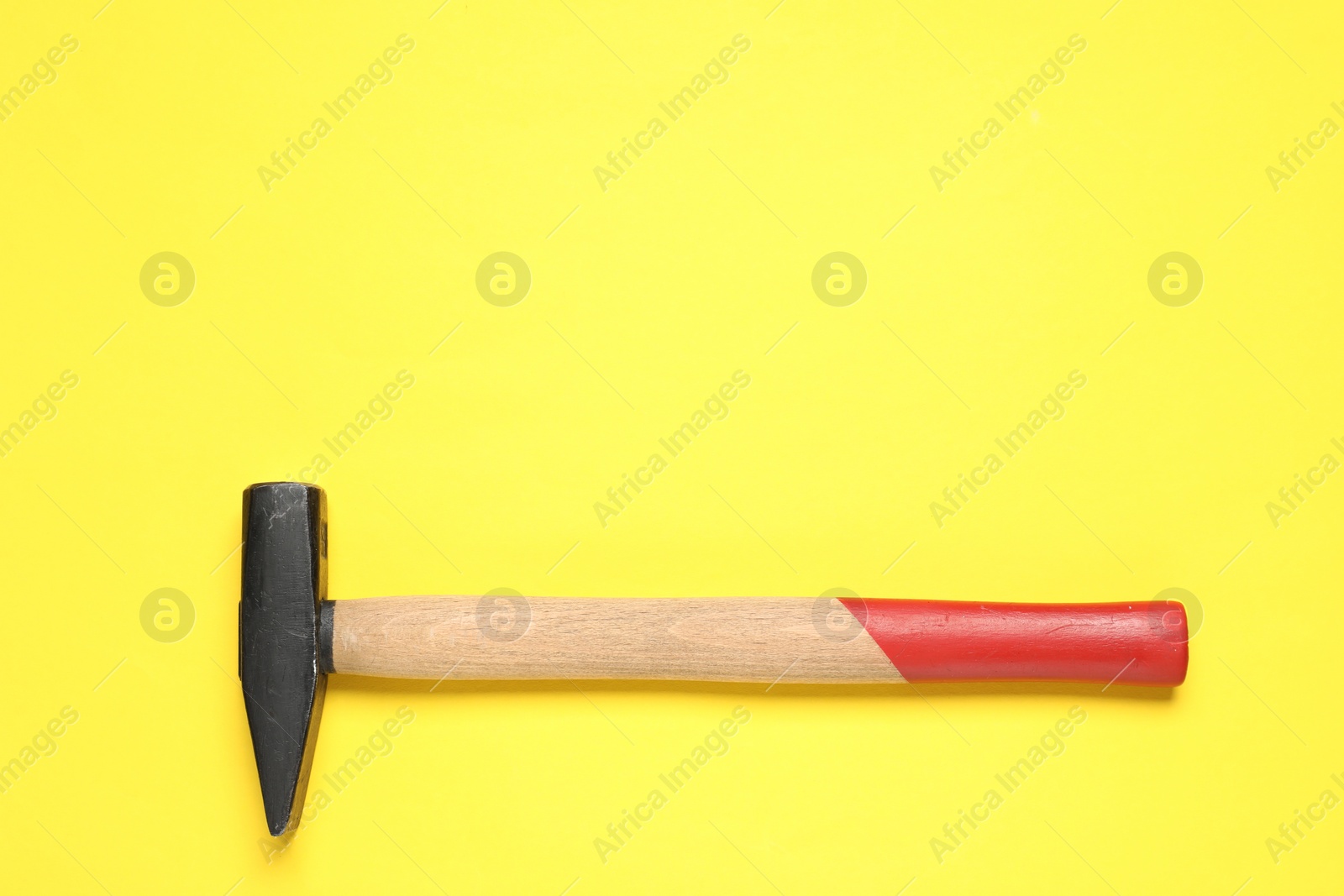 Photo of New hammer with wooden handle on yellow background, top view. Space for text