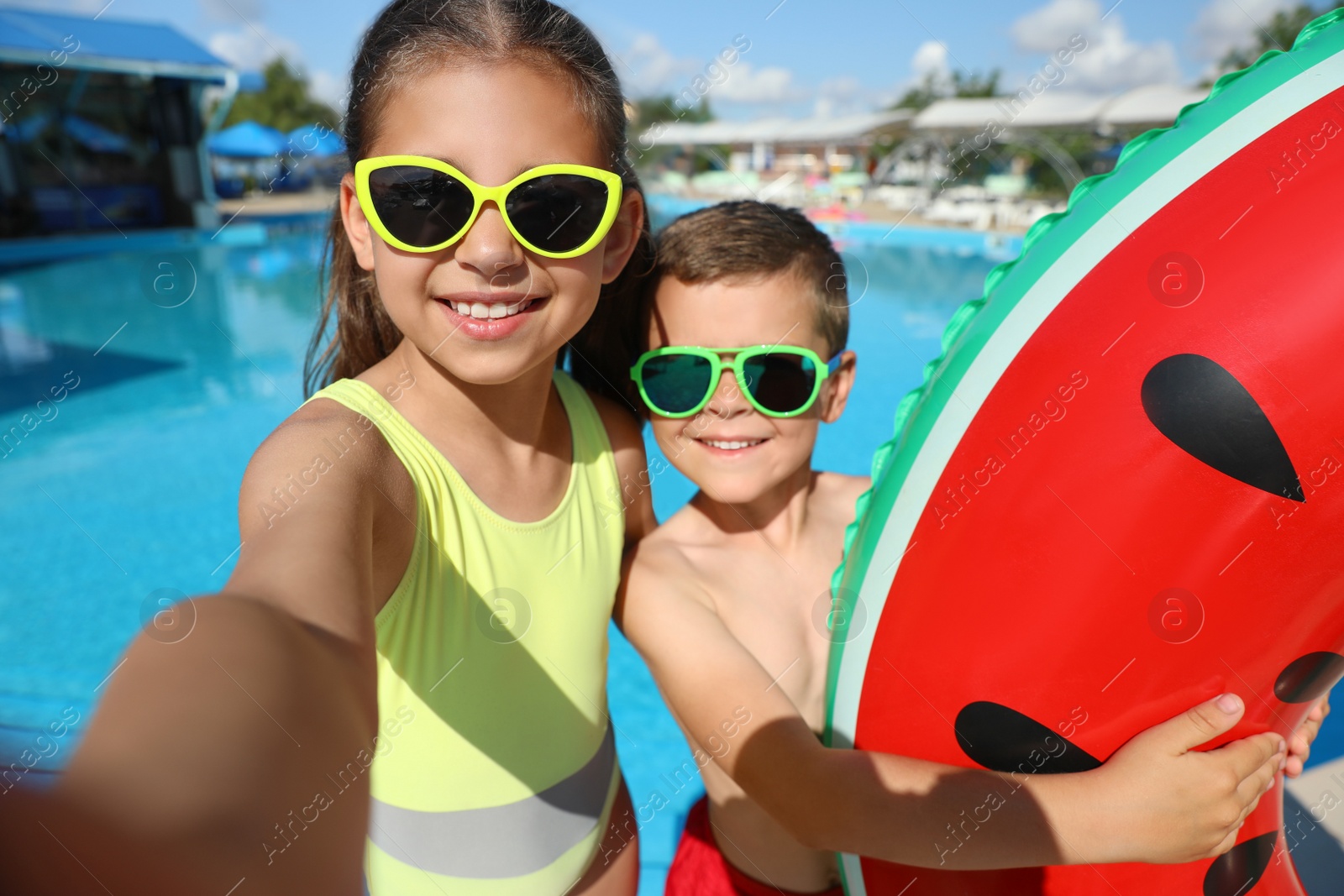 Photo of Happy children taking selfie near swimming pool. Summer vacation