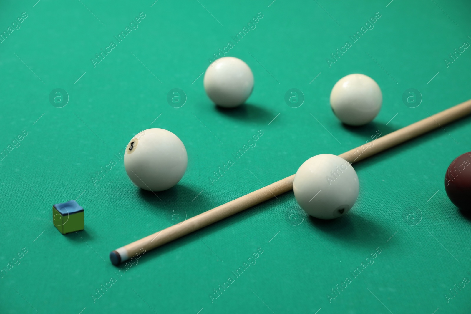 Photo of Billiard balls, cue and chalk on table