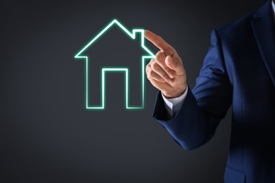 Image of Mortgage rate. Man touching illustration of house on virtual screen against dark background, closeup