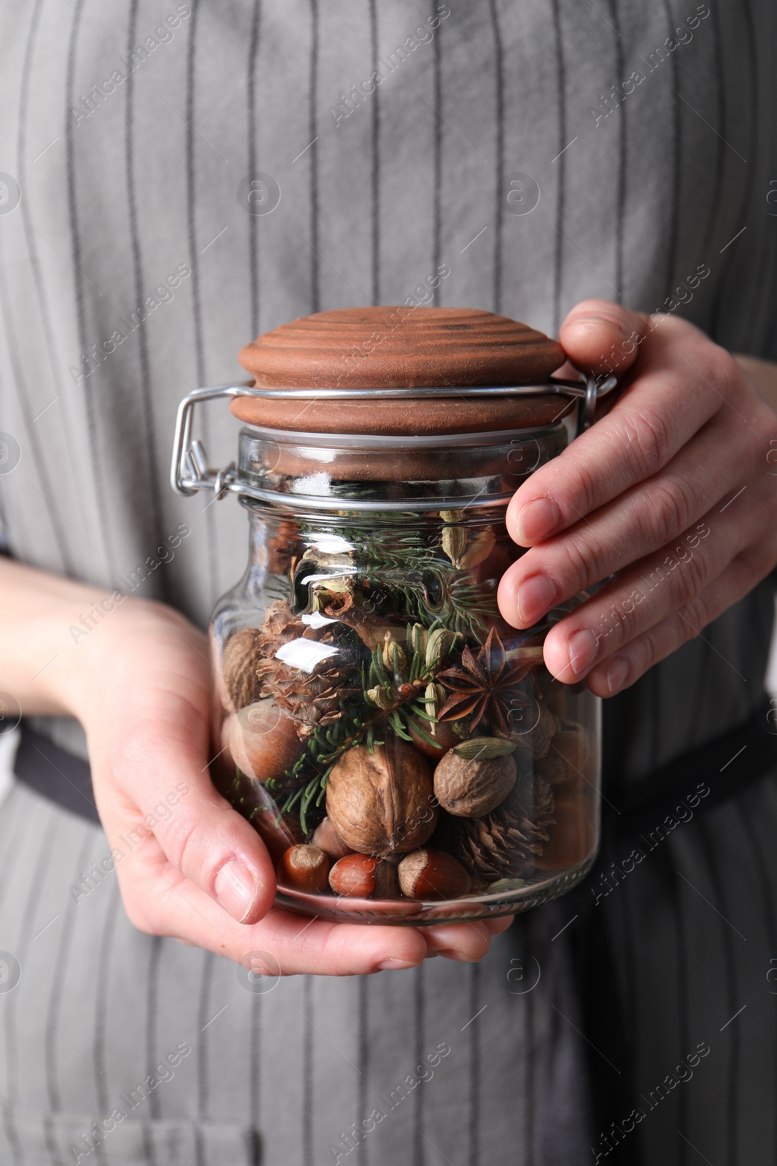 Photo of Woman holding jar with aromatic potpourri, closeup