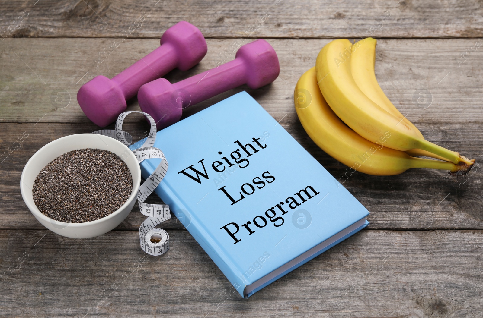 Photo of Weight loss concept. Notebook, fitness items and products on wooden table